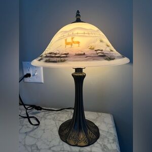 Nantucket brand lamp. Glass shade with winter scene. Base is a light metal.